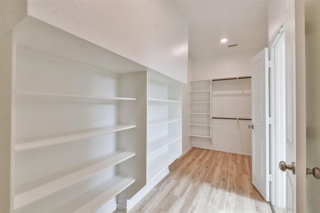 spacious closet with light hardwood / wood-style flooring