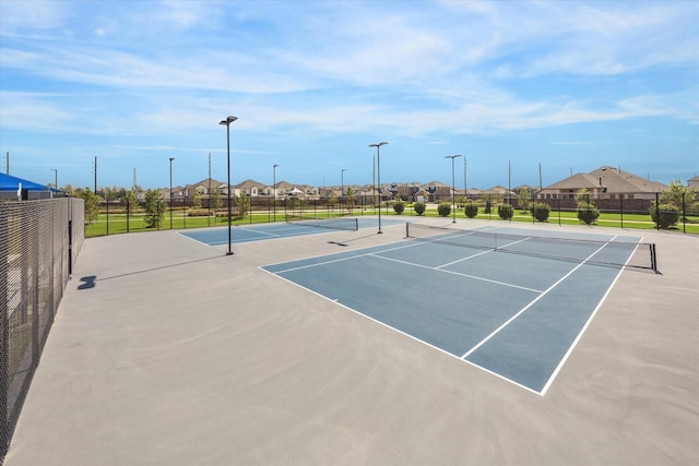 view of tennis court featuring basketball hoop