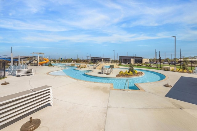 view of pool featuring a patio area and a water slide