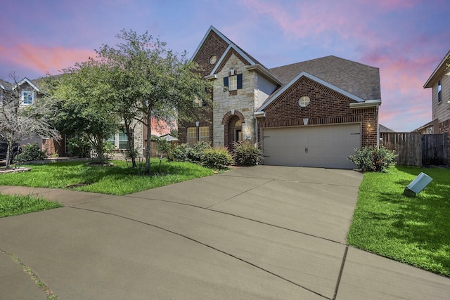 view of front of property featuring a garage and a lawn