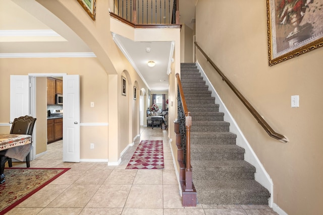 foyer entrance featuring crown molding and light tile patterned floors