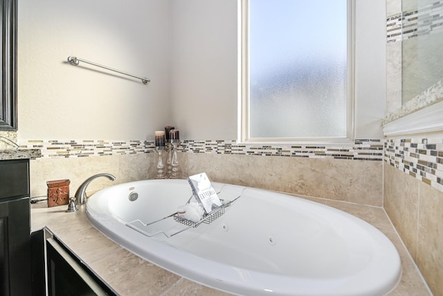 bathroom with a relaxing tiled tub and vanity