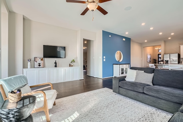 living room featuring ceiling fan and dark wood-type flooring