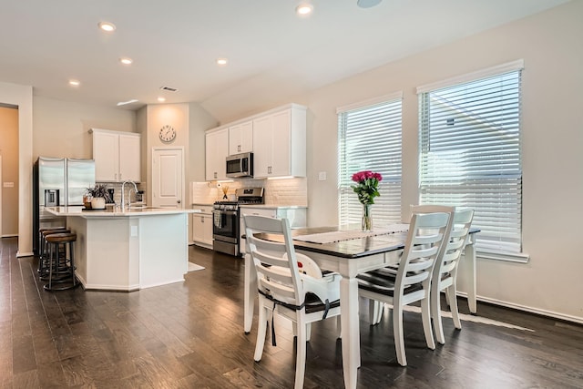 dining space featuring sink and dark wood-type flooring