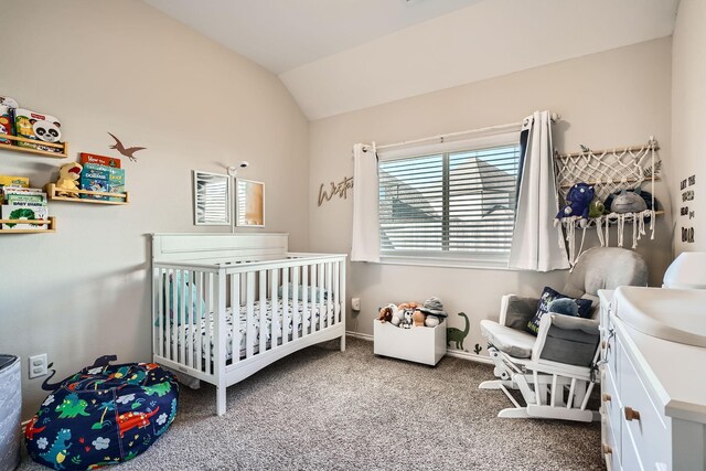 carpeted bedroom with a crib and lofted ceiling