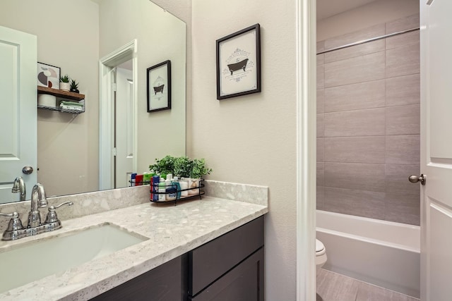 full bathroom with vanity, toilet, and tiled shower / bath