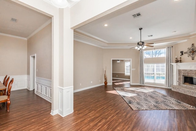 living room with dark hardwood / wood-style flooring, crown molding, a fireplace, and ceiling fan