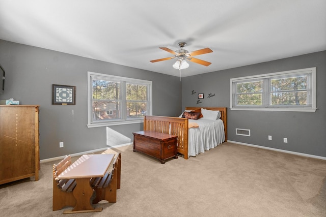 bedroom featuring multiple windows, ceiling fan, and light carpet