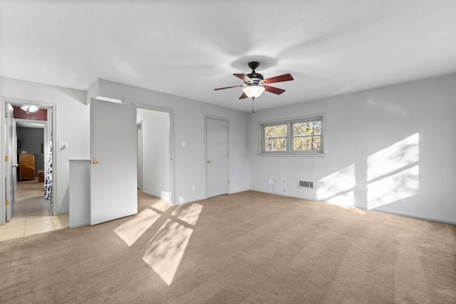 interior space featuring ceiling fan and light colored carpet