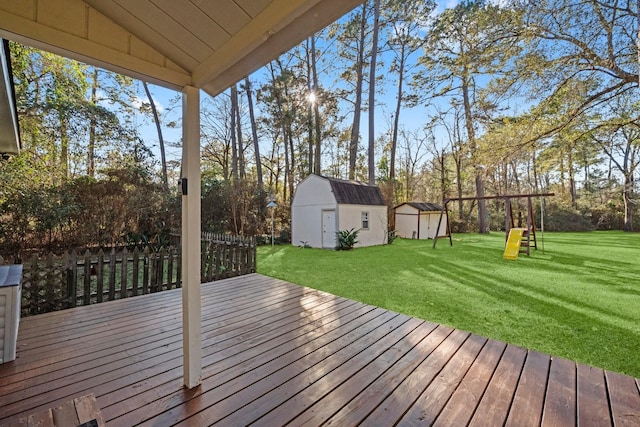 wooden deck with a playground, a storage unit, and a yard