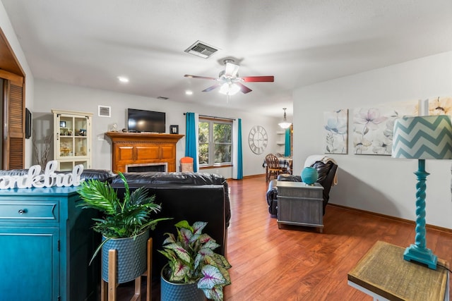 living room with ceiling fan and dark hardwood / wood-style flooring