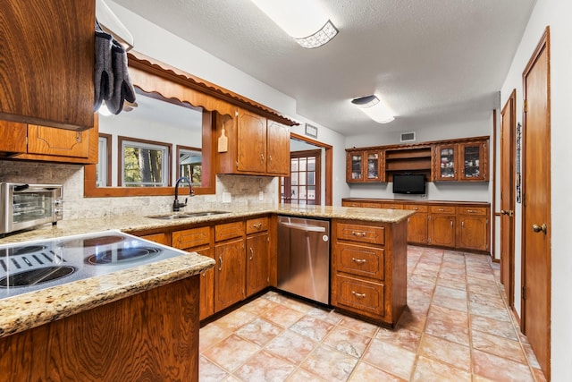 kitchen with dishwasher, sink, backsplash, kitchen peninsula, and a textured ceiling