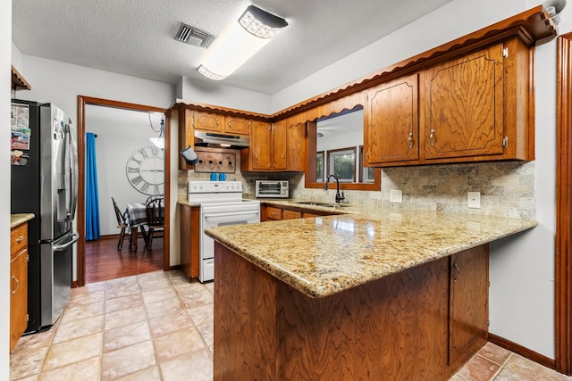 kitchen featuring kitchen peninsula, stainless steel fridge with ice dispenser, sink, and white stove