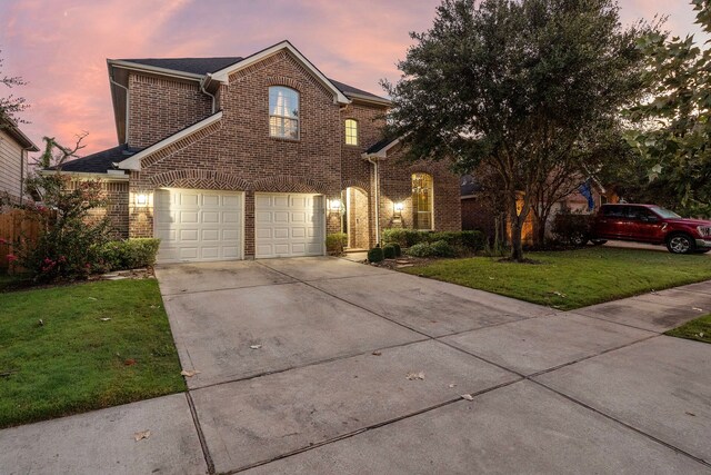 front facade with a yard and a garage