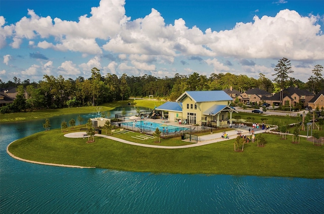 view of swimming pool featuring a lawn, a water view, and a patio