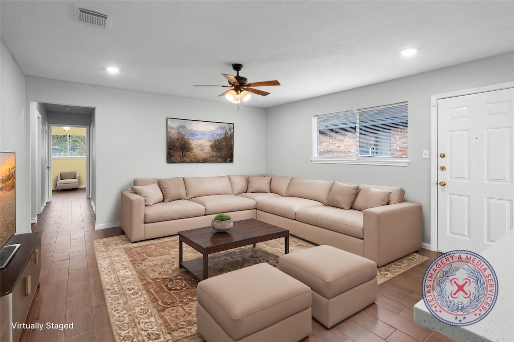 living room featuring light wood-type flooring and ceiling fan