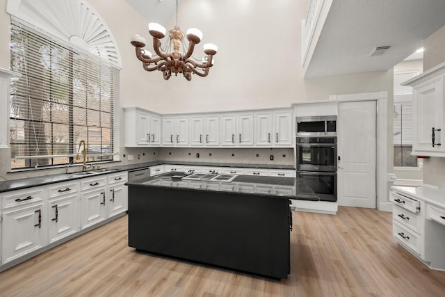 kitchen featuring sink, a center island, a towering ceiling, and tasteful backsplash