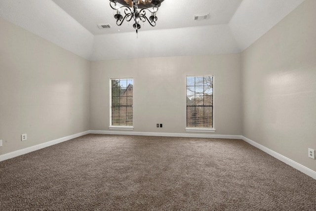 spare room featuring an inviting chandelier, vaulted ceiling, and carpet