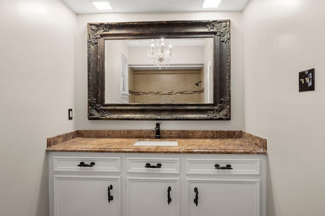 bathroom with a notable chandelier and vanity