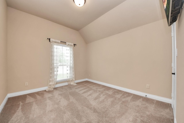 carpeted empty room with lofted ceiling