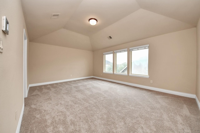 carpeted spare room with lofted ceiling