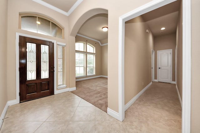 carpeted entryway featuring vaulted ceiling and crown molding