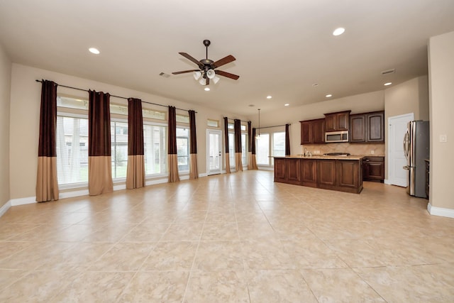 unfurnished living room with ceiling fan and light tile patterned floors