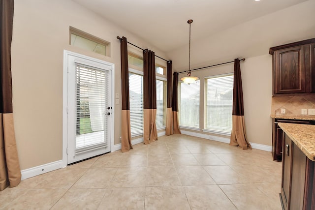 interior space featuring plenty of natural light, light tile patterned flooring, and lofted ceiling