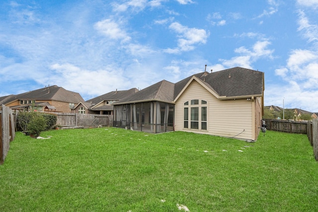 back of house featuring a yard and a sunroom