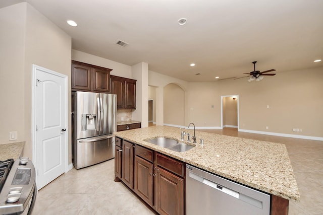 kitchen featuring stainless steel appliances, ceiling fan, sink, an island with sink, and light tile patterned flooring