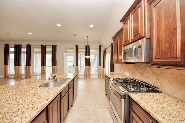 kitchen with light stone countertops, sink, decorative light fixtures, decorative backsplash, and appliances with stainless steel finishes