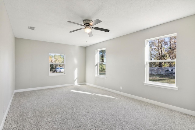 carpeted empty room with a textured ceiling and ceiling fan