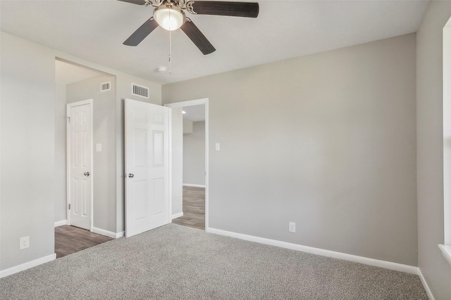 unfurnished bedroom featuring ceiling fan and dark carpet