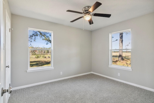 carpeted spare room featuring ceiling fan