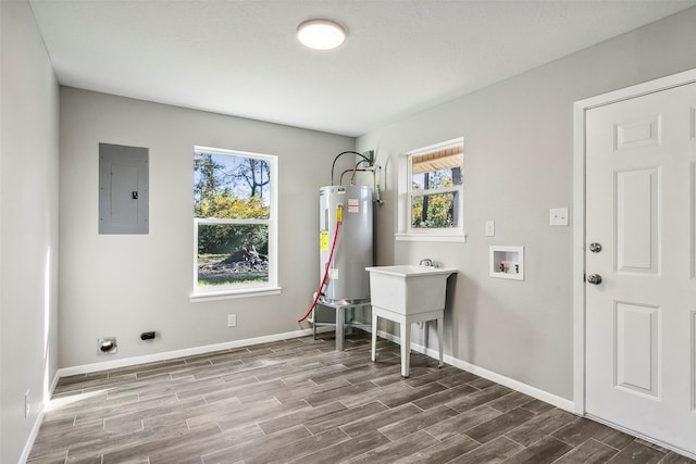 clothes washing area with sink, washer hookup, water heater, electric panel, and hardwood / wood-style flooring