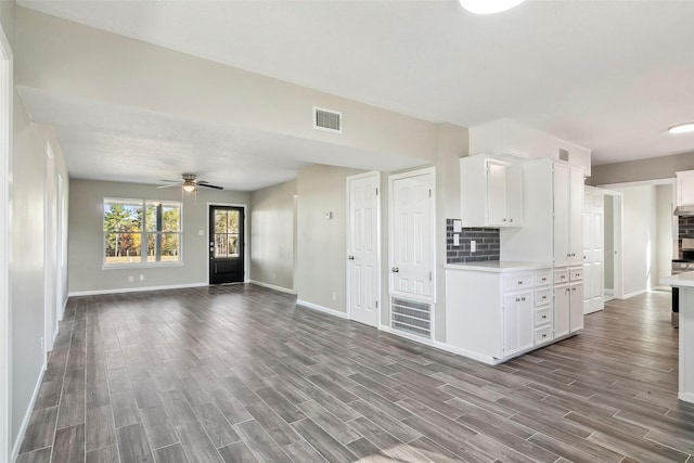 kitchen featuring white cabinets, ceiling fan, hardwood / wood-style flooring, and tasteful backsplash