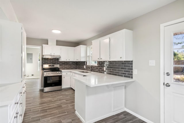 kitchen with kitchen peninsula, white cabinetry, sink, and stainless steel range