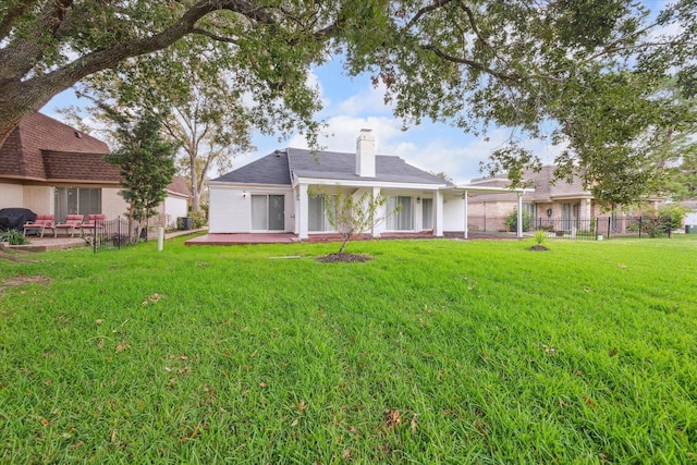 back of property featuring a lawn and a patio