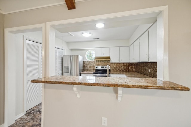 kitchen featuring backsplash, kitchen peninsula, a breakfast bar area, white cabinets, and appliances with stainless steel finishes