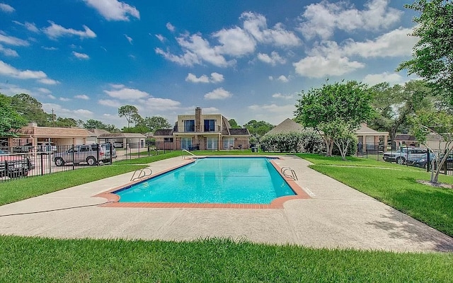 view of swimming pool featuring a lawn