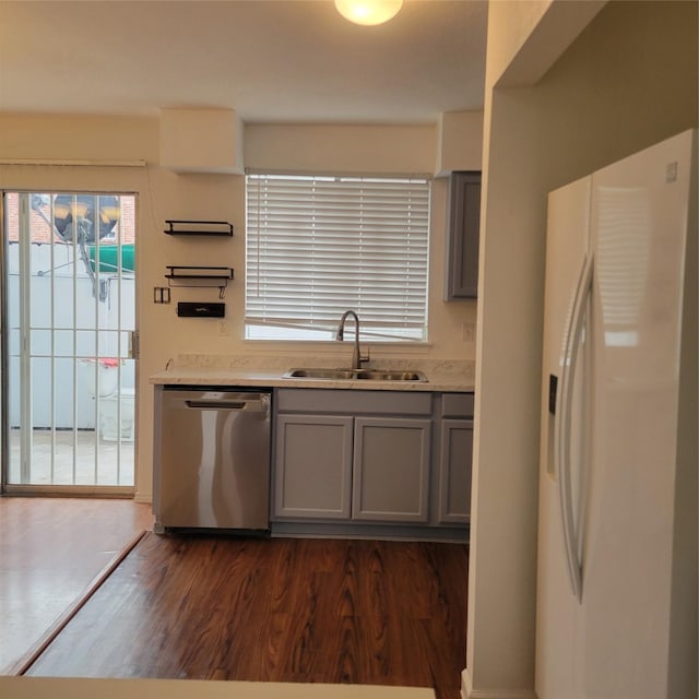 kitchen with white refrigerator with ice dispenser, gray cabinets, dishwasher, and sink