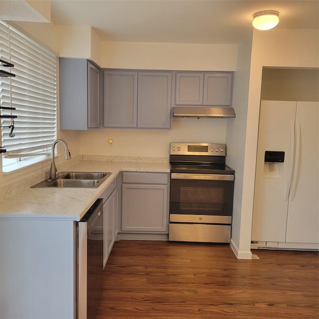 kitchen with gray cabinetry, dark hardwood / wood-style flooring, sink, and stainless steel appliances