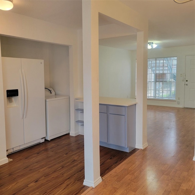 kitchen featuring hardwood / wood-style flooring, washer / dryer, and white fridge with ice dispenser