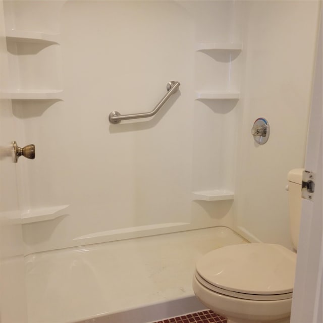 bathroom featuring tile patterned floors, toilet, and walk in shower