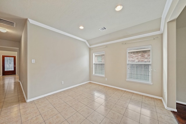 tiled spare room featuring a textured ceiling, crown molding, and lofted ceiling