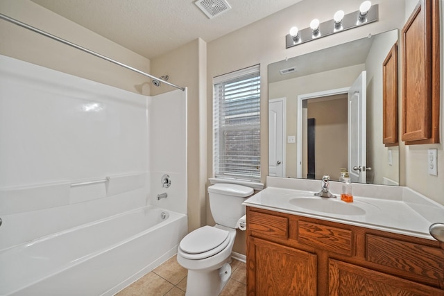 full bathroom featuring washtub / shower combination, tile patterned flooring, a textured ceiling, toilet, and vanity