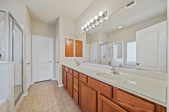 bathroom with tile patterned flooring, vanity, and a shower with shower door