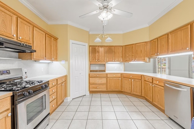 kitchen with hanging light fixtures, ceiling fan, ornamental molding, light tile patterned flooring, and stainless steel appliances