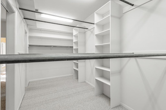 spacious closet featuring light colored carpet