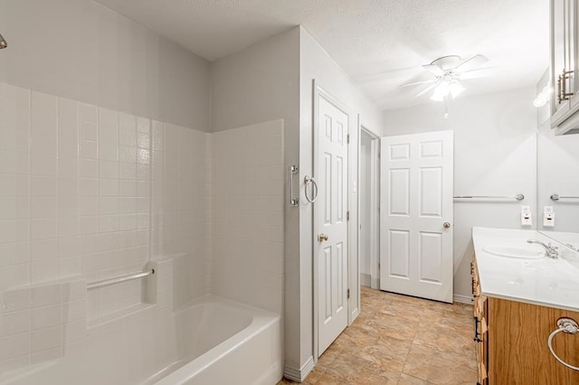 bathroom featuring ceiling fan, vanity, shower / bath combination, and a textured ceiling